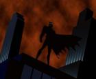 Бэтмен смотрит на город с крыши здания в Готэм-сити
